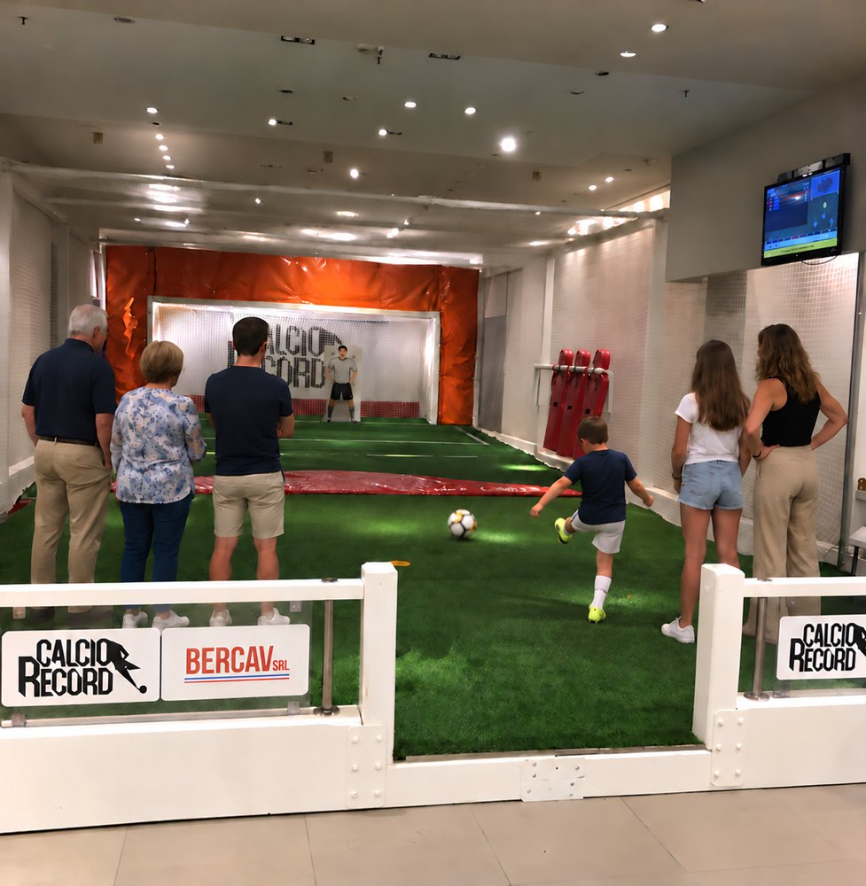 Tre generazioni di una famiglia condividono il gioco su una pista da calcio, riprese di spalle